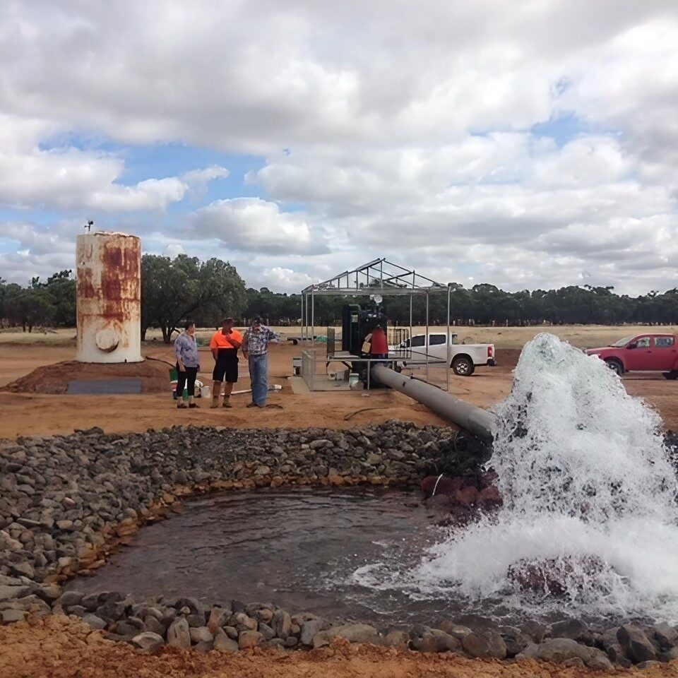 Water flowing from pipe into rocky pool